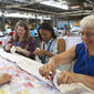 women gathered around a quilt