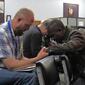 a black man and a white man hold hands in prayer