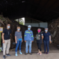 5 people stand in front of compost pile