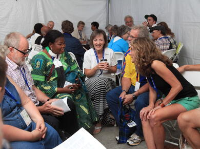 A diverse group of people sit talking in a circle