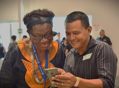 two people look at a mobile phone