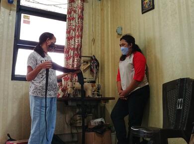 two masked women stand socially distanced while discussing