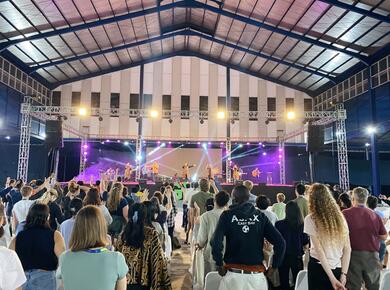 young people face a flashy stage in an open air auditorium