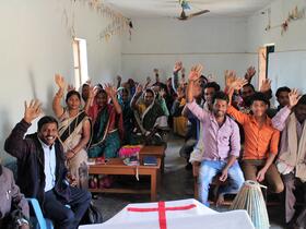 people in a church wave at the camera