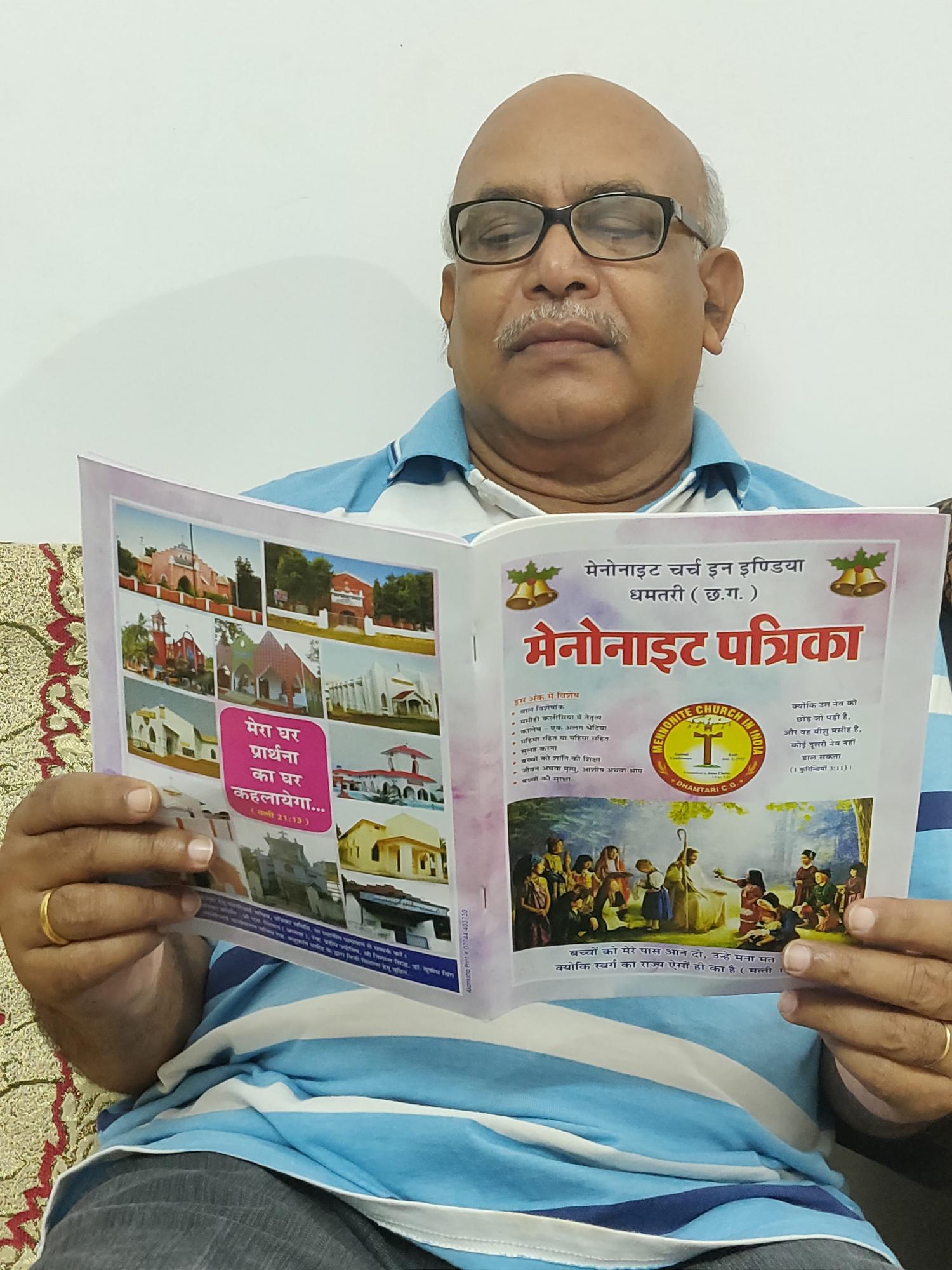 Harendra Milap, member of Mennonite Church Rajnandgaon and the publication committee, reads Mennonait Patrika, a quarterly magazine of Mennonite Church India Dhamtari CG. Photo supplied. 